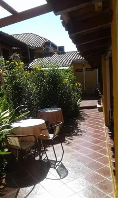 a patio with two tables and chairs and bushes at Tico Tico Apart in Mina Clavero