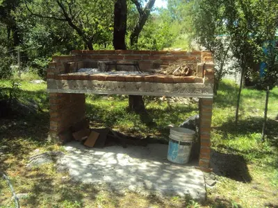 a brick fireplace in a field with a bucket at Cabañas Wayramuyu in Merlo
