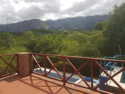 a wooden balcony with a view of mountains at Cabañas Wayramuyu in Merlo