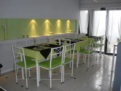 a dining room with green and white tables and chairs at Noria Hotel in Villa Carlos Paz