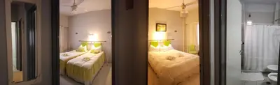 a bedroom with two beds and two lamps at Noria Hotel in Villa Carlos Paz