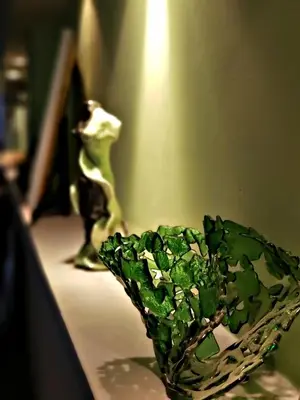 a green glass vase sitting on a table at Noria Hotel in Villa Carlos Paz