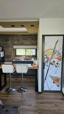 a kitchen with a table and two stools in a room at La Guarida del Zorro in Merlo