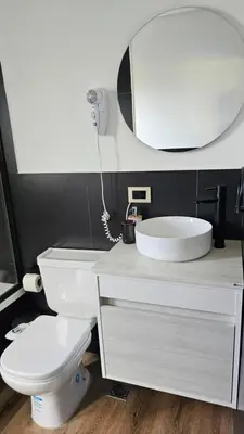 a bathroom with a toilet and a sink and a mirror at La Guarida del Zorro in Merlo