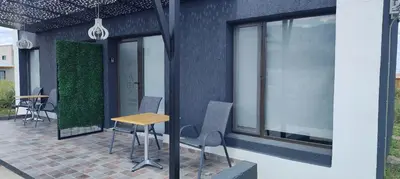 a patio with chairs and a table and windows at La Guarida del Zorro in Merlo