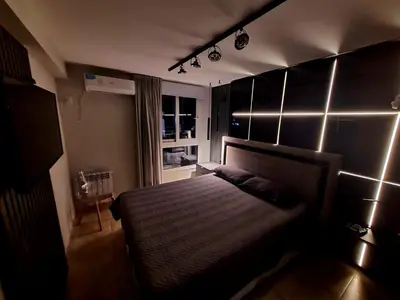 a bedroom with a bed with lights on the wall at DOMUS APART in Río Cuarto