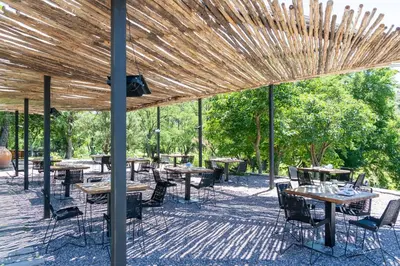 a patio with tables and chairs under a wooden pergola at Estancia Acuarela del Río in San Clemente