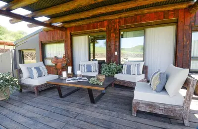 a patio with a table and chairs on a deck at Estancia Acuarela del Río in San Clemente