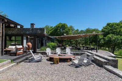 a patio with chairs and a table and a building at Estancia Acuarela del Río in San Clemente