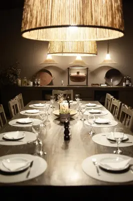 a long table with plates and glasses and a chandelier at Estancia Acuarela del Río in San Clemente