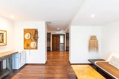 a living room with white walls and wooden floors at Estancia Acuarela del Río in San Clemente