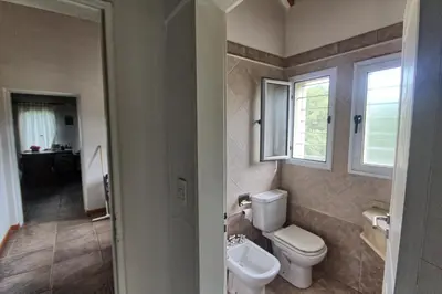 a bathroom with a toilet and a sink at Casas de Campo Henin in Villa General Belgrano