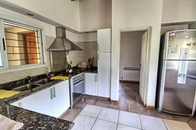 a kitchen with white cabinets and a stainless steel refrigerator at Casas de Campo Henin in Villa General Belgrano