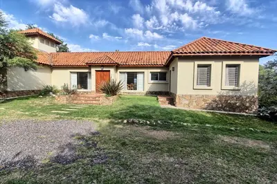 a house with a red roof and a yard at Casas de Campo Henin in Villa General Belgrano
