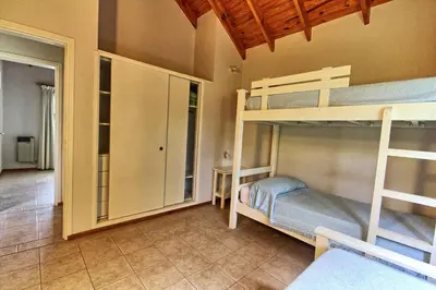 a room with two bunk beds and a closet at Casas de Campo Henin in Villa General Belgrano
