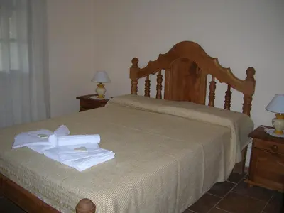 a bedroom with a bed with two towels on it at Cabañas El Refugio de Juan in Mina Clavero