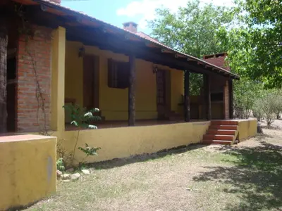a small yellow house with a brick building at Cabañas El Refugio de Juan in Mina Clavero