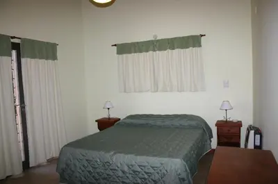 a bedroom with a bed and two night stands and two lamps at El Rincón del Molle in Merlo
