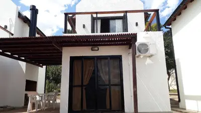 a white house with a door and a balcony at Ensueño in Santa Rosa de Calamuchita