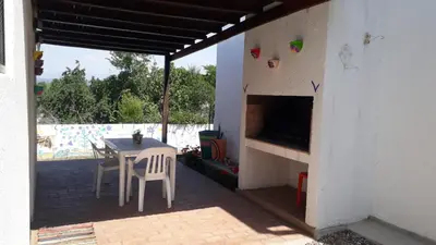 a patio with a table and chairs and a fireplace at Ensueño in Santa Rosa de Calamuchita