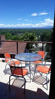 a table and chairs on a balcony with a view at Ensueño in Santa Rosa de Calamuchita