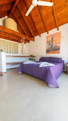 a large purple bed in a room with a ceiling at Ensueño in Santa Rosa de Calamuchita