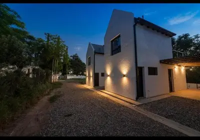 a white building with lights on the side of it at Ensueño in Santa Rosa de Calamuchita