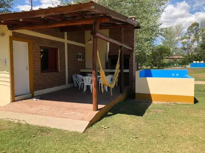 a patio with a hammock and a house at Cabañas La Querencia 2 dormitorios in Villa Cura Brochero