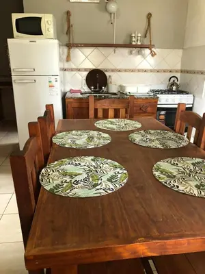 a kitchen with a wooden table with plates on it at Cabañas La Querencia 2 dormitorios in Villa Cura Brochero