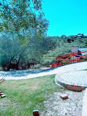 a walkway with a red fence and some grass at CAMINITOS in Villa General Belgrano
