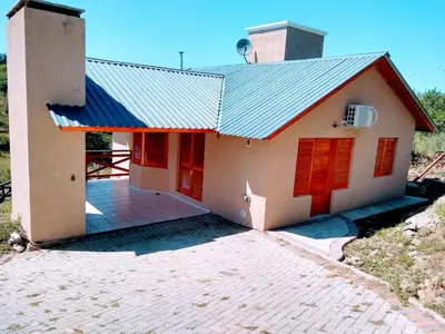 a house with red doors and a blue roof at CAMINITOS in Villa General Belgrano