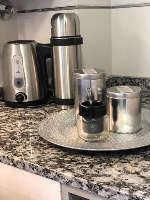 a counter top with two coffee makers on a plate at LitStay Brasil con cochera, pileta y asadores in Cordoba