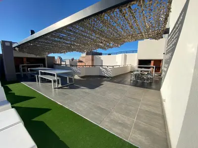 a rooftop patio with a table and chairs on a roof at LitStay Brasil con cochera, pileta y asadores in Cordoba
