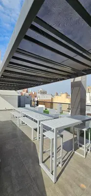 a group of white picnic tables on a roof at LitStay Brasil con cochera, pileta y asadores in Cordoba