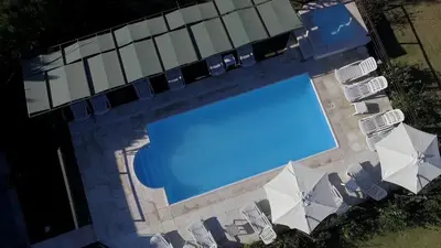 an overhead view of a swimming pool with lawn chairs and umbrellas at La Frida Hotel - ADULTS ONLY in Nono