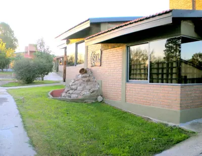 a building with a pile of rocks in front of it at Complejo Sol in Villa Carlos Paz