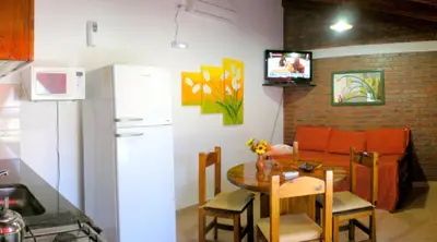 a kitchen with a small table and a refrigerator at Complejo Sol in Villa Carlos Paz