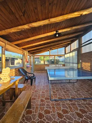 a room with a ping pong table and benches at Complejo Sol in Villa Carlos Paz