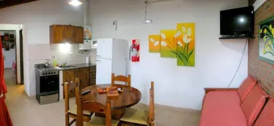 a kitchen with a table and a dining room at Complejo Sol in Villa Carlos Paz