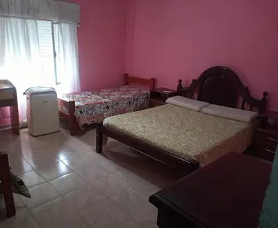 a room with two beds and a refrigerator in it at Casa a 5 km de Villa de Las Rosas in Las Tapias