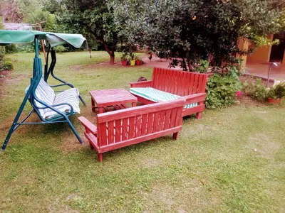 two red benches and a table and a swing at Casa a 5 km de Villa de Las Rosas in Las Tapias