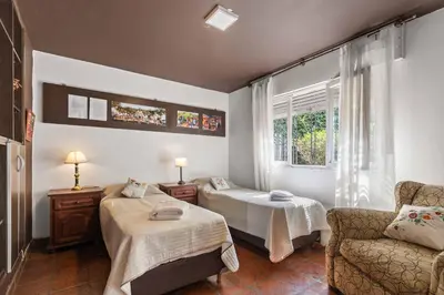a bedroom with two beds and a chair and a window at El Puerto - Cerca de todo in Cordoba