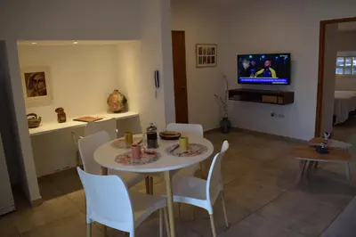 a dining room with a table and chairs and a tv at El Puerto - Cerca de todo in Cordoba