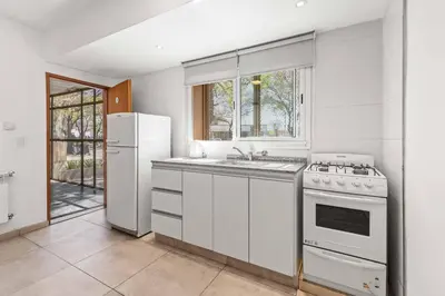a white kitchen with a stove and a refrigerator at El Puerto - Cerca de todo in Cordoba