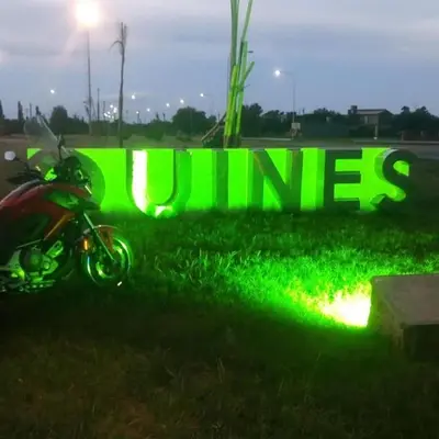 a motorcycle parked in front of a green neon sign at Ruta 20 HOUSE Quines in Quines
