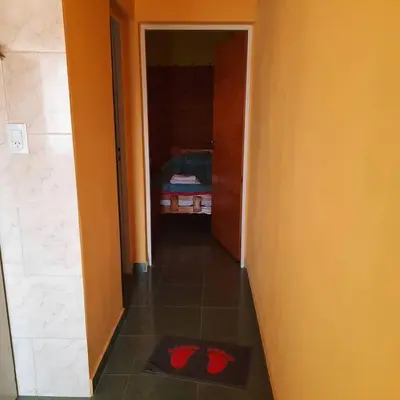 a hallway with a room with a bed and red shoes on the floor at Ruta 20 HOUSE Quines in Quines