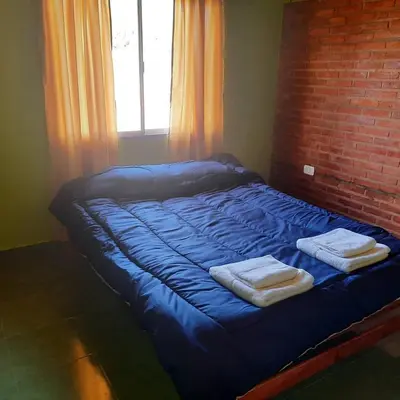 a blue bed with two towels on top of it at Ruta 20 HOUSE Quines in Quines