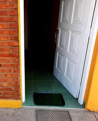 an open door with a black mat in front of it at Ruta 20 HOUSE Quines in Quines