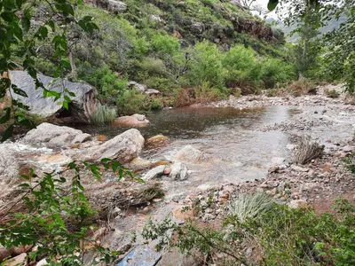 a stream of water with rocks on a mountain at Ruta 20 HOUSE Quines in Quines