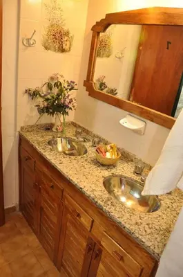 a bathroom with two sinks and a mirror at Casa grande La Querencia in Villa Cura Brochero
